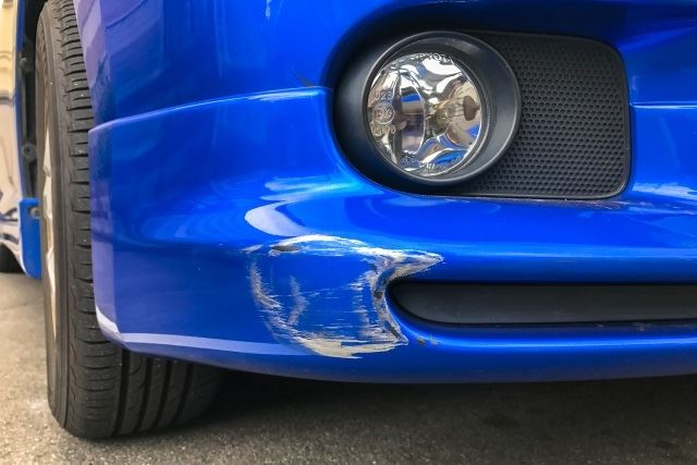 フロントバンパーに傷が入った青の車